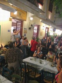 アテネ、キダシネオン通りにあるお店で、歌って踊る陽気な人達